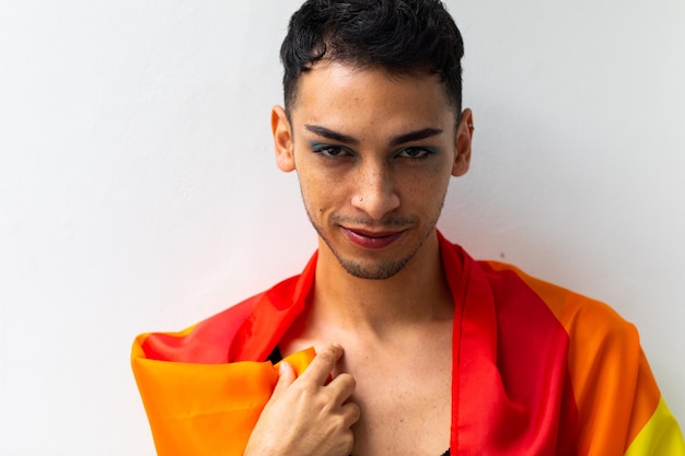 Photo portrait of happy biracial transgender man holding rainbow flag on white background. gender, lgbtq, pride and lifestyle, unaltered.