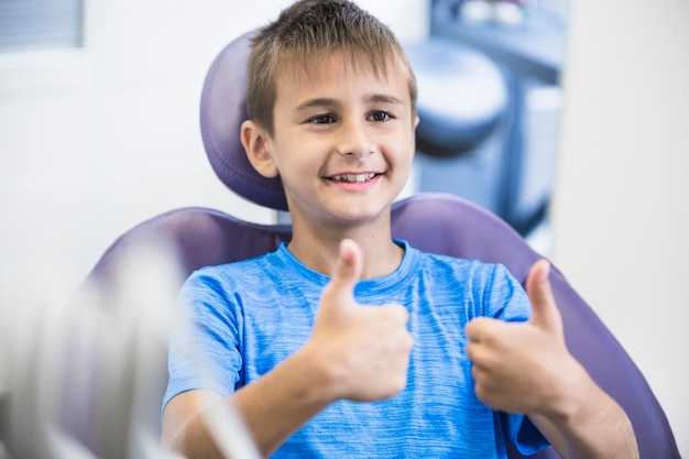 Portrait of a happy boy gesturing thumbs up in clinic