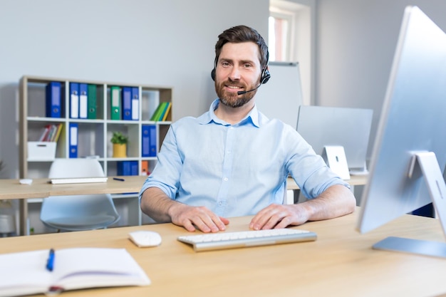 Portrait of a happy businessman man working remotely using a headset for a video call