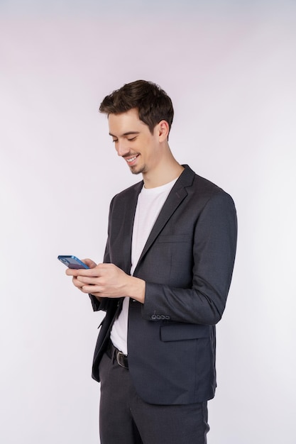 Portrait of a happy businessman using smartphone over white background