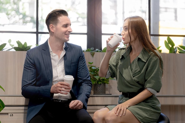 Portrait of happy businessman and woman hold cup of coffee at coffee cafe counter bat with nature biophilia for wellness life