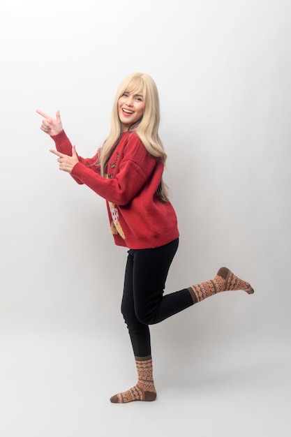 Portrait of happy Caucasian young woman in Christmas sweater over white background