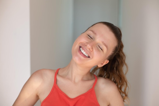 Portrait of happy cheerful positive girl young joyful woman is smiling at home at sunny day looking