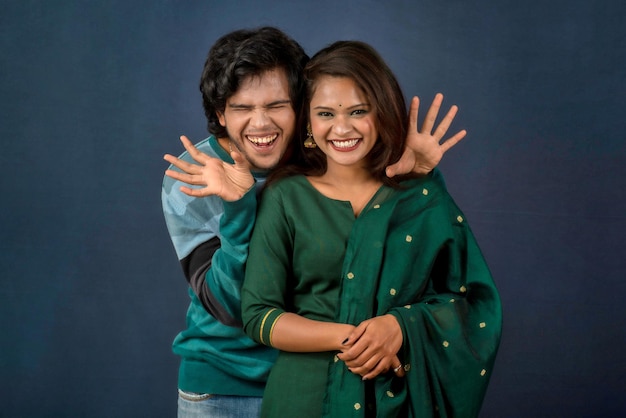 Portrait of a happy cheerful young couple posing on dark background Attractive man and woman being playful