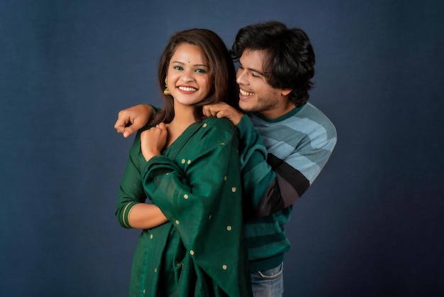 Portrait of a happy cheerful young couple posing on dark background Attractive man and woman being playful