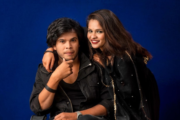 Portrait of a happy cheerful young couple posing on dark background Attractive man and woman being playful