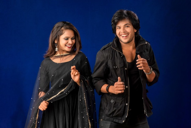 Portrait of a happy cheerful young couple posing on dark background Attractive man and woman being playful