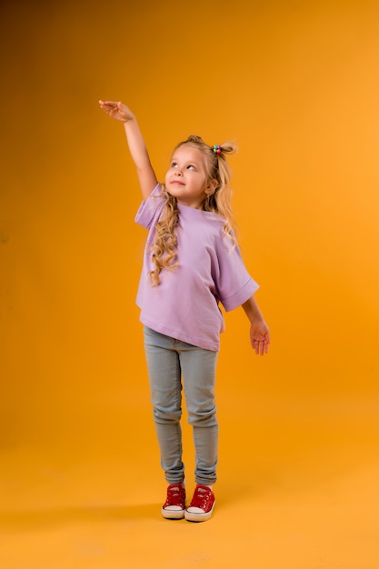 portrait of a happy child girl isolate on a yellow space, space for text