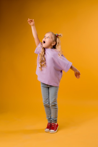 portrait of a happy child girl isolate on a yellow space, space for text