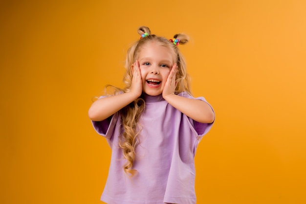 portrait of a happy child girl isolate on a yellow space, space for text