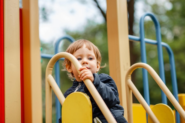 Portrait of happy child outdoors cute boy playing on playground