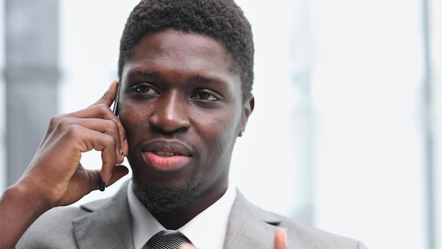 Portrait of a happy confident young african american businessman standing with his arms crossed looking at camera