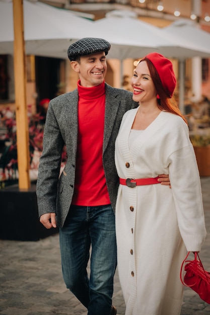 Portrait of a happy couple walking on the street in an autumn city Stylish couple in retro style in autumn in the city