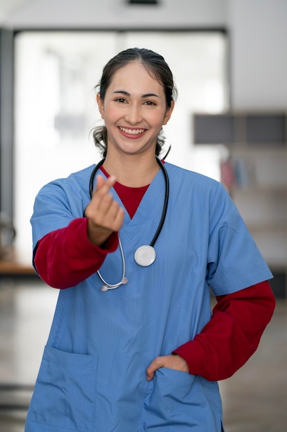 Portrait of happy doctor or nurse at hospital corridor showing mini heart