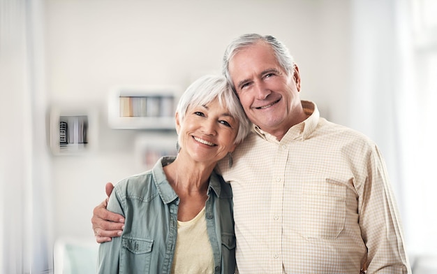 Portrait of a happy elderly couple standing together in their home