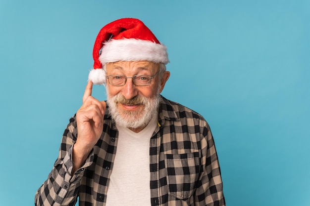 Portrait of happy emotions Santa Claus excited looking at camera on blue background with copy space