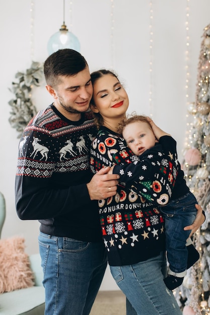 Portrait of happy family of father mother and little curly son celebrating Christmas together at home New Years Eve concept