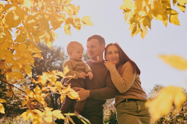 Portrait happy family mom dad and son having fun and enjoying spending time together in autumn park on sunny day Love and loyalty young parents