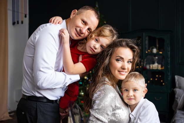 Portrait of happy family mother father and little children enjoying time together on holidays Merry Christmas and Happy New Year