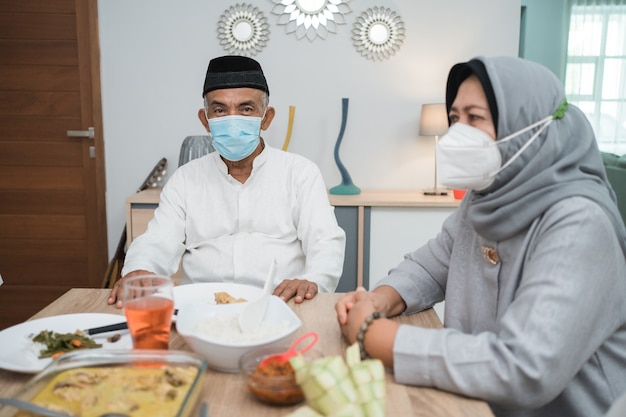 Portrait of happy family muslim wear mask during eid mubarak celebration at home