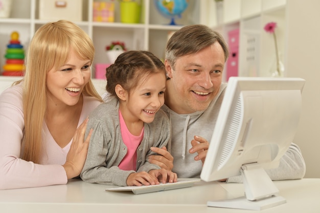 Portrait of happy family playing  on computer at home