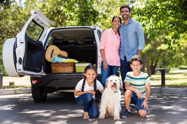 Portrait of happy family next to their car having fun