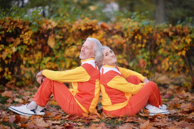 Portrait of happy fit senior couple in autumn park