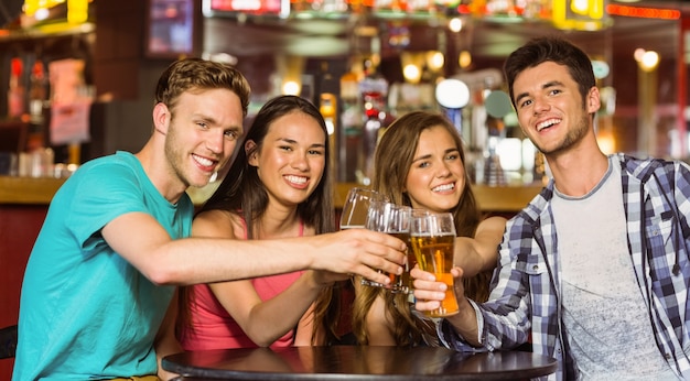 Portrait of happy friends toasting with drink and beer