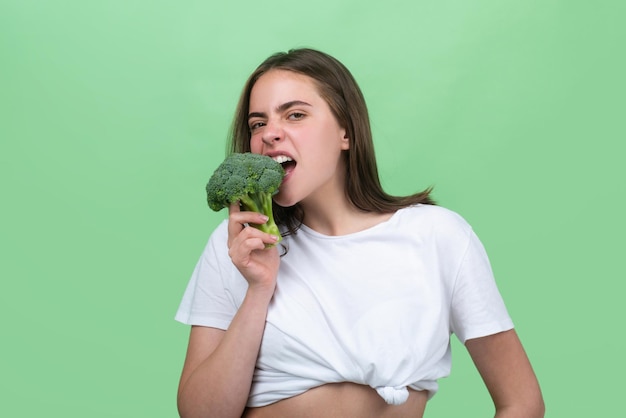 Portrait of happy funny young beautiful woman eating broccoli healthy food health life