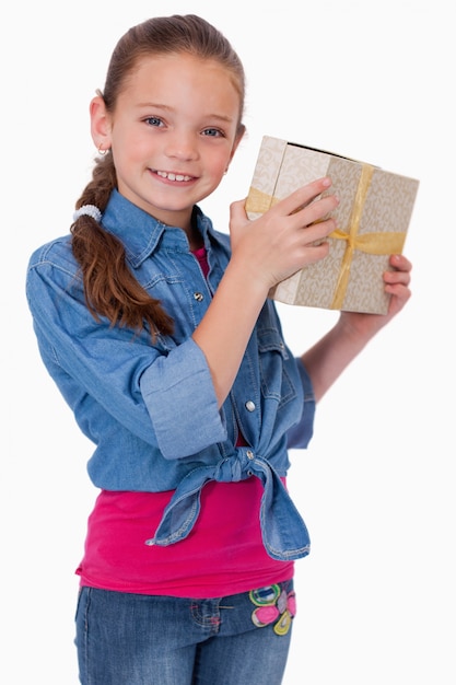 Portrait of a happy girl holding a gift box