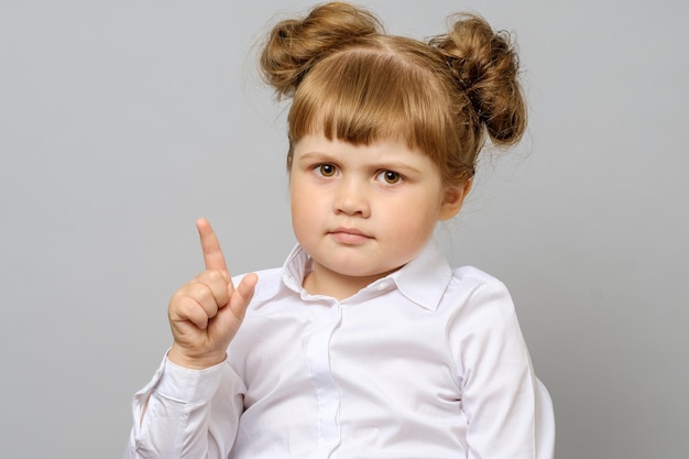 Portrait of happy girl pointing up isolated