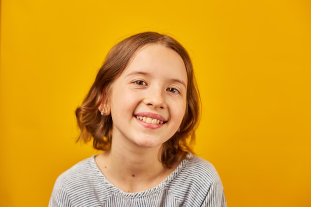 Portrait happy girl teenage in yellow studio background positive emotions lifestyle