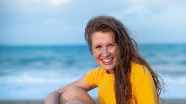 Portrait of happy girl young carefree woman enjoying summer vacation on sea walking on beach sand