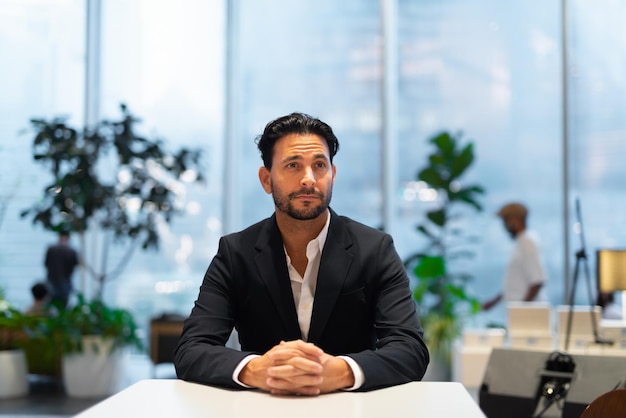 Portrait of happy handsome Hispanic businessman at coffee shop thinking