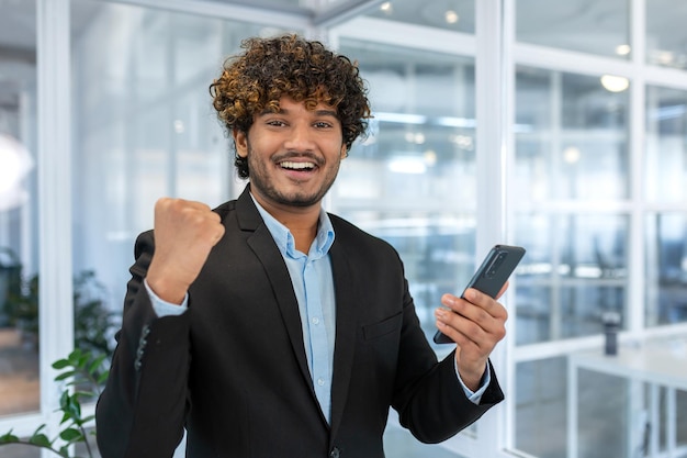 Portrait of happy hispanic businessman man celebrating achievement good results and victory boss