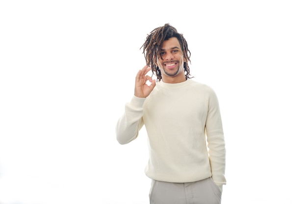 Portrait of a happy latin man showing OK gesture to the camera while standing over an isolated background.