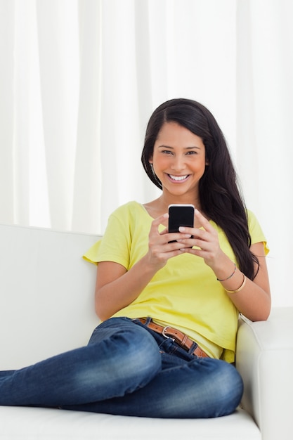 Portrait of a happy Latino looking her smartphone