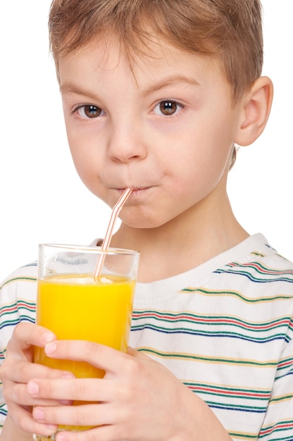 Portrait of happy little boy drinking refreshing orange juice Smiling child with glass of fresh lemonade