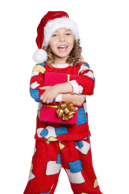 Portrait of happy Little girl in pajamas and santa hat with gift box over white background