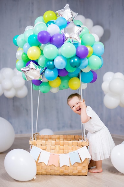 Portrait of happy little girl with colorful air balloons