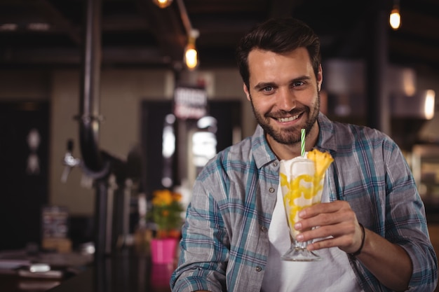 Portrait of happy man having milkshake