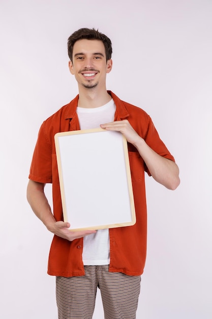 Portrait of happy man showing blank signboard on isolated white background