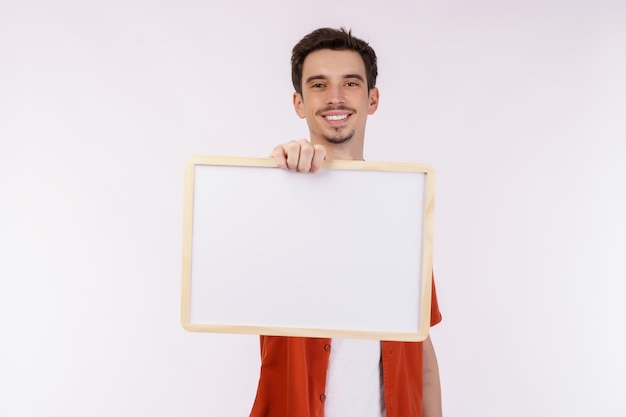 Portrait of happy man showing blank signboard on isolated white background