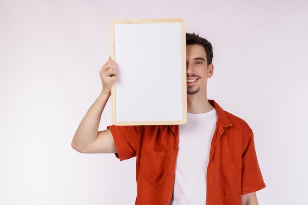 Portrait of happy man showing blank signboard on isolated white background