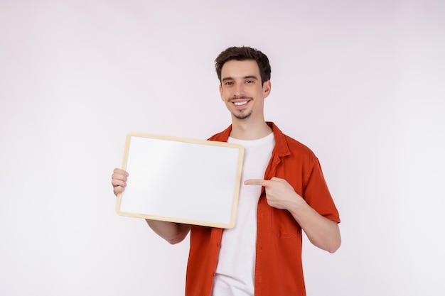 Portrait of happy man showing blank signboard on isolated white background