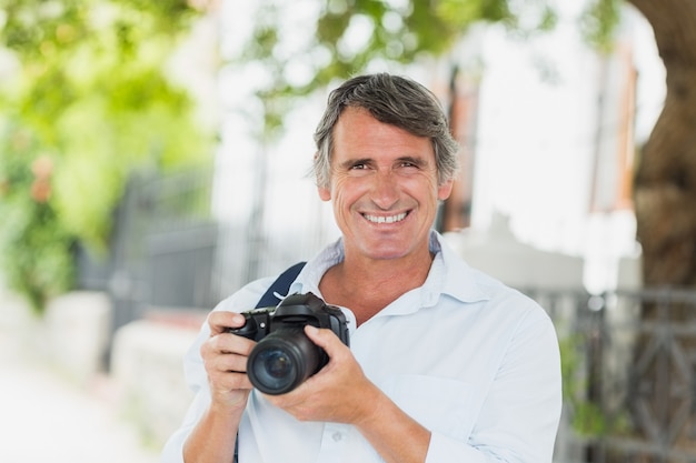 Portrait of happy man with camera