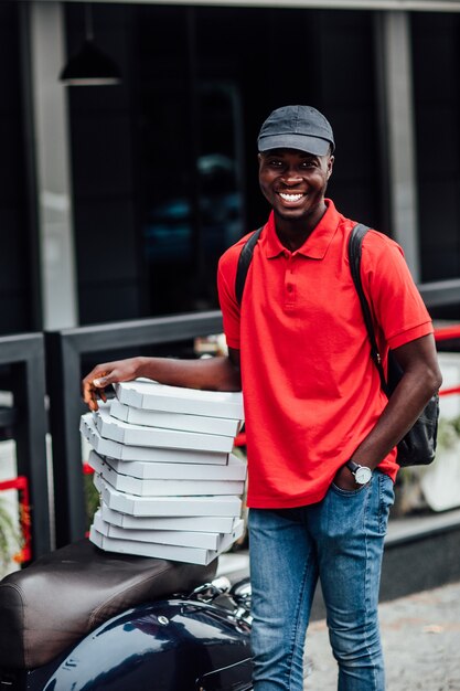 Photo portrait of happy man works on scooter, conveys fast food from restaurant for customers. take your order.