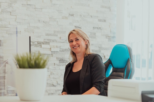 Portrait of a happy manager at bright office Smiling at camera while sitting at office deskHigh quality photo