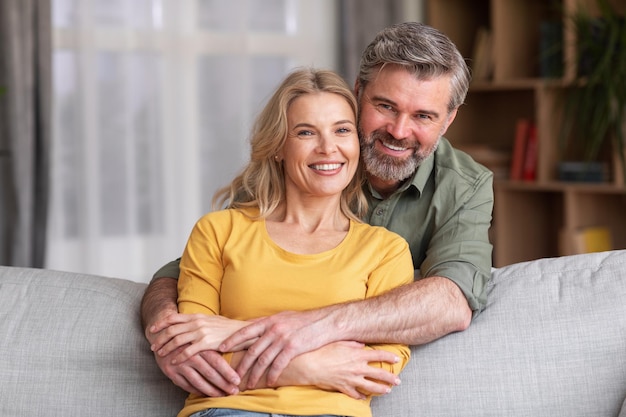 Portrait Of Happy Middle Aged Husband And Wife Posing At Home Interior