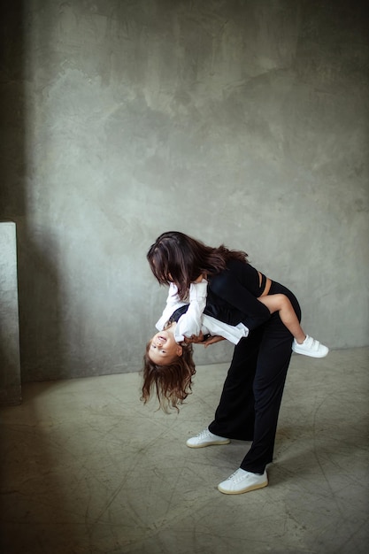 Portrait of happy mom with daughter 3 years old who have fun in loft interior